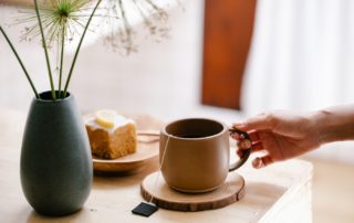 Hand holding steeping teacup