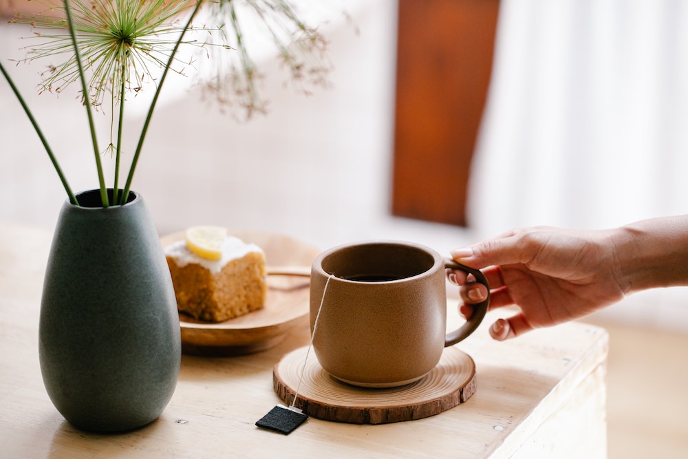 Hand holding steeping teacup